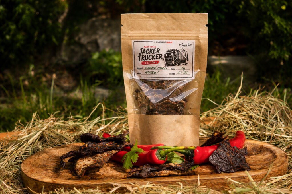 Uzené hovězí jerky Chilli na dřevěném prkně s chilli papričkami, edice Jacker Trucker